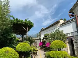 Courtyard with lush vegetation and mountains in the background.